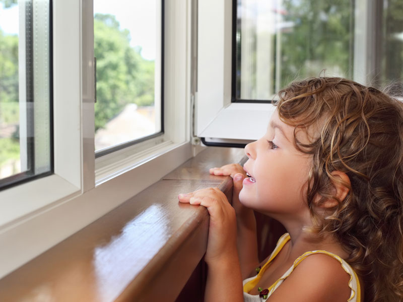 child-looking-out-windows Lady drinking coffee and enjoying her new windows.